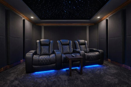 Luxury dedicated home theater room with dark leather recliners and acoustic wall panels
